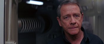 Movie still from “Leviathan” (1989), directed by George P. Cosmatos – An older man is looking into the camera; Close Up shot, Over the shoulder angle