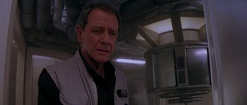 Movie still from “Leviathan” (1989), directed by George P. Cosmatos – An older man standing in front of an air conditioner unit; Close Up shot, Over the shoulder angle