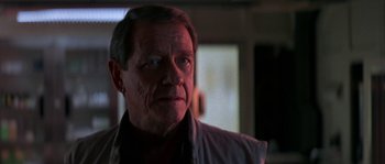 Movie still from “Leviathan” (1989), directed by George P. Cosmatos – An older man is looking into the camera; Close Up shot, Over the shoulder angle