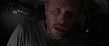 Movie still from “Leviathan” (1989), directed by George P. Cosmatos – A person's face in a dark room; Close Up shot, Low angle