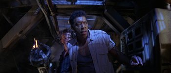 Movie still from “Leviathan” (1989), directed by George P. Cosmatos – A man standing next to another man in a room; Medium shot, Low angle