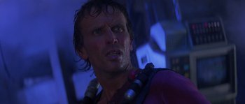 Movie still from “Leviathan” (1989), directed by George P. Cosmatos – A person wearing a purple shirt; Close Up shot, Low angle