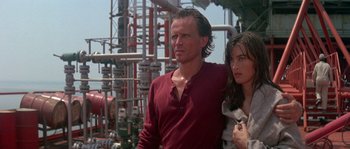Movie still from “Leviathan” (1989), directed by George P. Cosmatos – A man and a woman standing next to each other in front of pipes; Close Up shot, Low angle
