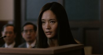 Movie still from “Like Father, Like Son” (2013), directed by Kore-eda Hirokazu – A woman with long brown hair sitting in front of a judge; Close Up shot, Low angle