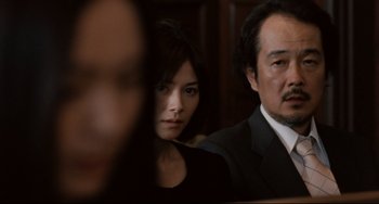 Movie still from “Like Father, Like Son” (2013), directed by Kore-eda Hirokazu – A man and a woman in a suit and tie; Close Up shot, Over the shoulder angle