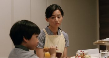 Movie still from “Like Father, Like Son” (2013), directed by Kore-eda Hirokazu – A woman sitting at a table next to a child; Medium shot, Over the shoulder angle