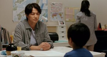 Movie still from “Like Father, Like Son” (2013), directed by Kore-eda Hirokazu – A man sitting at a table with a child; Medium shot, Over the shoulder angle