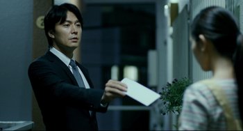 Movie still from “Like Father, Like Son” (2013), directed by Kore-eda Hirokazu – A man in a business suit holding a piece of paper; Medium shot, Over the shoulder angle