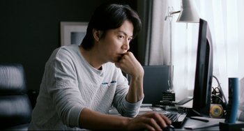 Movie still from “Like Father, Like Son” (2013), directed by Kore-eda Hirokazu – A man sitting in front of a computer keyboard; Medium shot, Over the shoulder angle