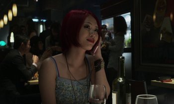 Movie still from “Like Someone in Love” (2012), directed by Abbas Kiarostami – A woman sitting at a table with a glass of wine; Close Up shot, Over the shoulder angle