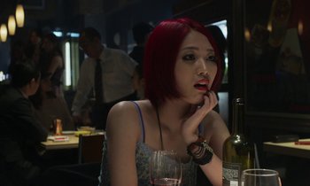 Movie still from “Like Someone in Love” (2012), directed by Abbas Kiarostami – A woman sitting at a table with a glass of wine; Close Up shot, Over the shoulder angle