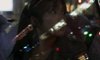 Movie still from “Like Someone in Love” (2012), directed by Abbas Kiarostami – A woman is looking out a window at night; Extreme Close Up shot, High angle