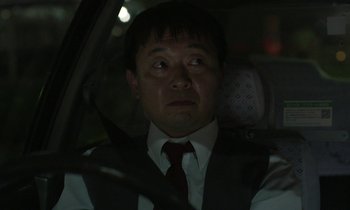 Movie still from “Like Someone in Love” (2012), directed by Abbas Kiarostami – A man in a suit and tie driving in a car at night; Close Up shot, Low angle