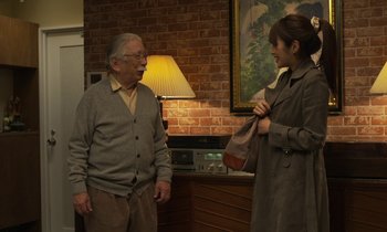 Movie still from “Like Someone in Love” (2012), directed by Abbas Kiarostami – An older man and a young woman talking in a living room; Medium shot, Over the shoulder angle