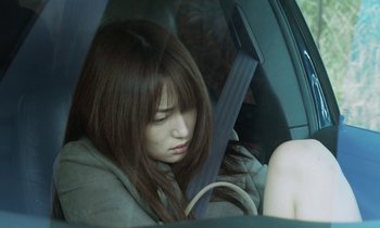 Movie still from “Like Someone in Love” (2012), directed by Abbas Kiarostami – A woman sitting in the back seat of a car; Close Up shot, Over the shoulder angle