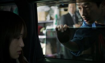 Movie still from “Like Someone in Love” (2012), directed by Abbas Kiarostami – A woman looking in a car window at a man in a suit; Close Up shot, Over the shoulder angle