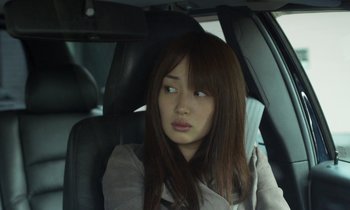 Movie still from “Like Someone in Love” (2012), directed by Abbas Kiarostami – A woman sitting in the back seat of a car; Close Up shot, Over the shoulder angle