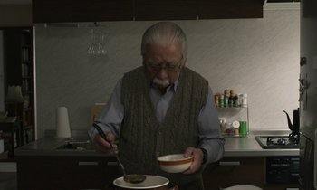 Movie still from “Like Someone in Love” (2012), directed by Abbas Kiarostami – An older man is eating a bowl of soup; Medium shot, Low angle