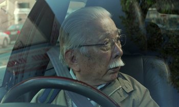 Movie still from “Like Someone in Love” (2012), directed by Abbas Kiarostami – An older man with a mustache driving a car; Close Up shot, Low angle