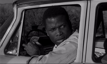 Movie still from “Lilies of the Field” (1963), directed by Ralph Nelson – A black and white photo of a man in the driver's seat of a car holding money; Close Up shot, Over the shoulder angle