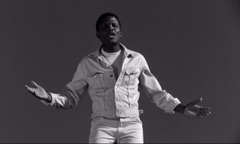 Movie still from “Lilies of the Field” (1963), directed by Ralph Nelson – A black and white photo of a man holding a hula hoop; Medium shot, Low angle