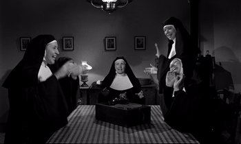 Movie still from “Lilies of the Field” (1963), directed by Ralph Nelson – A group of nuns sitting at a table with a suitcase; Medium shot, High angle