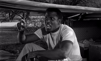 Movie still from “Lilies of the Field” (1963), directed by Ralph Nelson – A black and white photo of a man holding a baseball bat; Close Up shot, Low angle