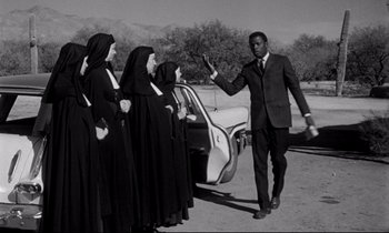 Movie still from “Lilies of the Field” (1963), directed by Ralph Nelson – A black and white photo of a man in a suit; Medium shot, Low angle