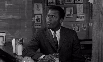 Movie still from “Lilies of the Field” (1963), directed by Ralph Nelson – A black and white photo of a man in a suit and tie; Close Up shot, Low angle
