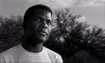 Movie still from “Lilies of the Field” (1963), directed by Ralph Nelson – A black and white photo of a man looking up at the sky; Close Up shot, Low angle