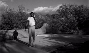 Movie still from “Lilies of the Field” (1963), directed by Ralph Nelson – A black and white photo of a man talking on a cell phone; Wide shot, Low angle