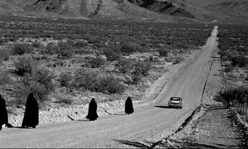 Movie still from “Lilies of the Field” (1963), directed by Ralph Nelson – A couple of people standing on the side of a dirt road; Extreme Wide shot, High angle