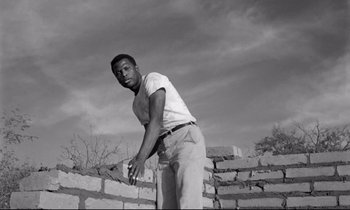 Movie still from “Lilies of the Field” (1963), directed by Ralph Nelson – A black and white photo of a man holding a frisbee; Medium shot, Low angle