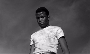 Movie still from “Lilies of the Field” (1963), directed by Ralph Nelson – A black and white photo of a man in a t - shirt; Medium shot, Low angle