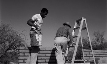 Movie still from “Lilies of the Field” (1963), directed by Ralph Nelson – Two men are painting a brick wall with a ladder; Medium shot, Low angle