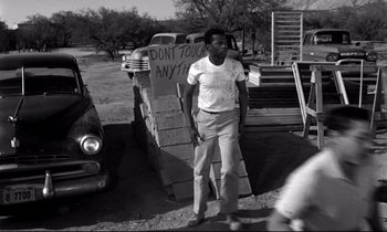 Movie still from “Lilies of the Field” (1963), directed by Ralph Nelson – A black and white photo of a man standing in front of a truck; Wide shot, Low angle