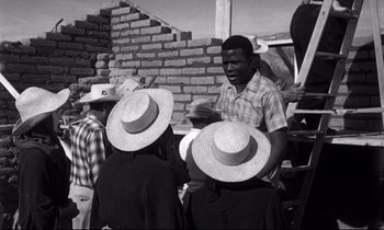 Movie still from “Lilies of the Field” (1963), directed by Ralph Nelson – A group of people standing next to each other wearing hats; Medium shot, Over the shoulder angle