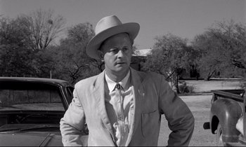 Movie still from “Lilies of the Field” (1963), directed by Ralph Nelson – A black and white photo of a man wearing a suit and a hat; Medium shot, Over the shoulder angle