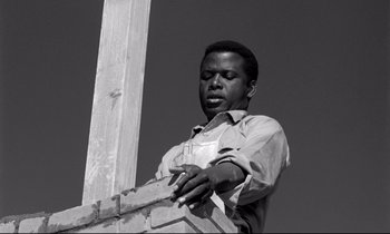 Movie still from “Lilies of the Field” (1963), directed by Ralph Nelson – A black and white photo of a man working on a fence; Close Up shot, Low angle