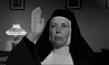 Movie still from “Lilies of the Field” (1963), directed by Ralph Nelson – An old woman wearing a nun's habit and holding up her right hand; Close Up shot, Low angle