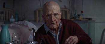 Movie still from “Little Big Man” (1970), directed by Arthur Penn – An old man sitting in front of a table; Close Up shot, Low angle