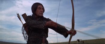Movie still from “Little Big Man” (1970), directed by Arthur Penn – An older man is holding a bow and arrow; Medium shot, Low angle