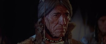Movie still from “Little Big Man” (1970), directed by Arthur Penn – An older native american man wearing a headdress; Close Up shot, Low angle