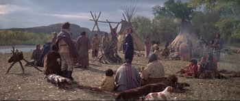 Movie still from “Little Big Man” (1970), directed by Arthur Penn – A group of native americans gathered in a field; Wide shot, Over the shoulder angle