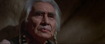 Movie still from “Little Big Man” (1970), directed by Arthur Penn – An older man with long white hair looking at the camera; Close Up shot, Low angle