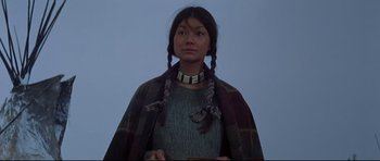 Movie still from “Little Big Man” (1970), directed by Arthur Penn – A woman with braids wearing a sweater and a plaid cape; Close Up shot, Low angle