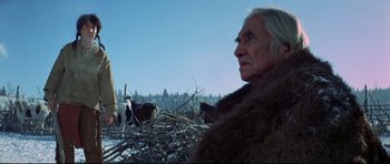 Movie still from “Little Big Man” (1970), directed by Arthur Penn – An older man in a fur coat standing in front of a herd of cattle; Close Up shot, Low angle