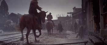 Movie still from “Little Big Man” (1970), directed by Arthur Penn – A group of people riding horses in a town; Wide shot, Low angle