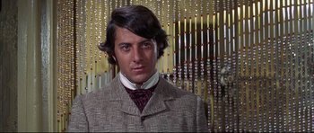 Movie still from “Little Big Man” (1970), directed by Arthur Penn – A man wearing a suit and tie in front of a wall; Close Up shot, Low angle