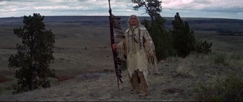 Movie still from “Little Big Man” (1970), directed by Arthur Penn – An old man standing on top of a hill holding a spear; Wide shot, Low angle